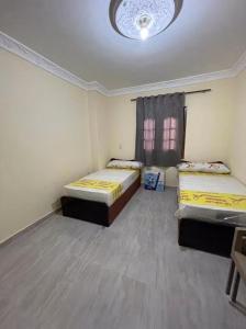 a room with two beds and a ceiling at Newytr home in Kafr al Ishārah