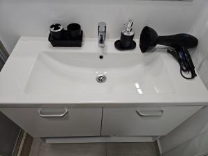 a white sink with a hairbrush and a hair dryer at Blue Sea OLIMP by Any - Etaj PREMIUM cu vedere la Mare in Olimp +6 photos
