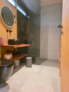 a bathroom with a black toilet and a mirror at Villa Beach Charly in Tisno