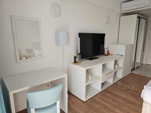 a white room with a desk and a television at Blue Sea OLIMP by Any - Etaj PREMIUM cu vedere la Mare in Olimp