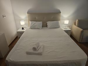 a large white bed with two towels on it at Blue Sea OLIMP by Any - Etaj PREMIUM cu vedere la Mare in Olimp