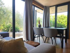 a living room with a table and chairs and windows at Villa Beach Charly in Tisno +13 photos