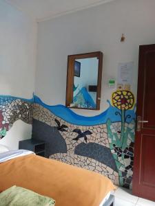 a bedroom with a mosaic wall with a mirror at Pondok IJo Guesthouse in Yogyakarta