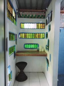 a bathroom with a shelf with green bottles on the wall at Pondok IJo Guesthouse in Yogyakarta +19 photos