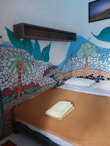 a bedroom with a mosaic mural on the wall at Pondok IJo Guesthouse in Yogyakarta