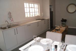 a kitchen with a table with wine glasses on it at Chalet Duiker in Ladismith