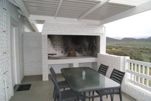 a patio with a fireplace and a table and chairs at Chalet Duiker in Ladismith +8 photos