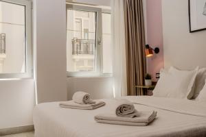 a bedroom with towels on a bed with a window at Rooster Suites in Athens