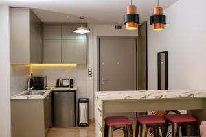 a kitchen with a counter with red stools in it at Rooster Suites in Athens