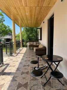 a patio with a table and chairs and a couch at Sea Breeze House Ureki in Ozurgetʼi