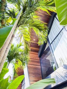 a house with palm trees in front of it at Superior Luxury Loft with Working Desk, Instagramable Pool in Kerobokan
