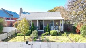 a small house with a white fence in front of it at Awen Cottage in Tenterfield