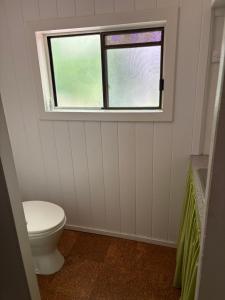 a bathroom with a toilet and a window at Awen Cottage in Tenterfield +13 photos