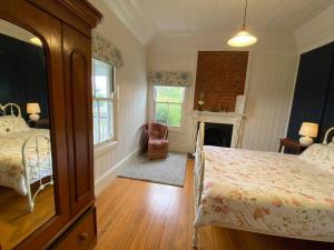 a bedroom with two beds and a fireplace at Awen Cottage in Tenterfield