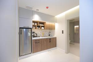 a kitchen with wooden cabinets and a stainless steel refrigerator at شاليهات واجهة الشفا in Taif