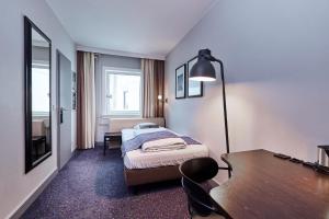 a bedroom with a bed and a desk and a table at Hotel Cabinn Vejle in Vejle