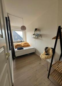 a small bedroom with a bed and a window at Hygge Home Aalborg, Free Parking & 15 Min to City Centre in Nørresundby