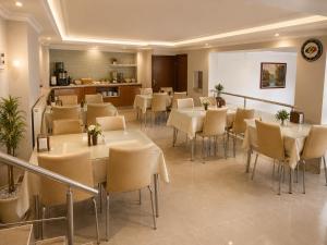 a restaurant with tables and chairs in a room at Çorlu Aras Hotel & City Center Location in Çorlu
