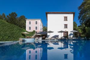 a hotel with a pool in front of a building at Archontiko Naoumidi in Portaria