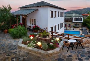 a house with a patio with a table and chairs at Archontiko Naoumidi in Portaria