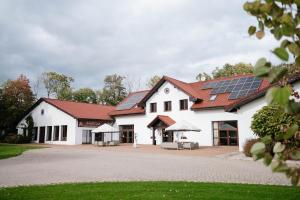 ein weißes Haus mit Solarpaneelen auf dem Dach in der Unterkunft Bagatelka Cenrum Rekreacyjno-Hotelowe in Miłosław