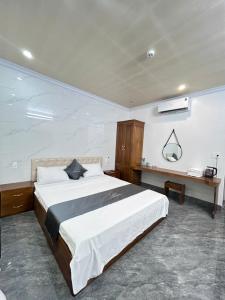 a bedroom with a large bed and a desk at Cloudy Hotel in Ha Giang