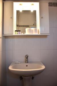 a white bathroom with a sink and a mirror at Sxoleio Apartment in Kamariotissa +18 photos