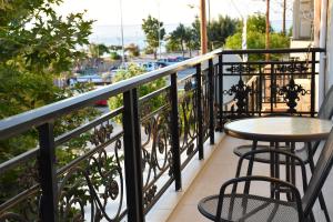 a balcony with a table and chairs and a view at Sxoleio Apartment in Kamariotissa