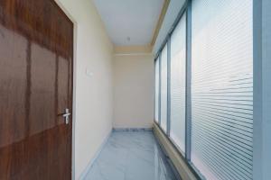 a hallway with a wooden door and a window at Super Hotel O The Dev Regency in Patna