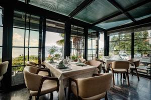 a restaurant with tables and chairs and large windows at Hotel Dva Bisera in Ohrid