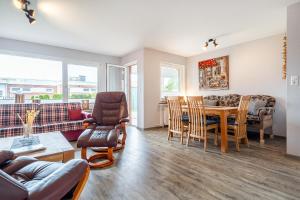 a living room with a table and chairs at Bungalow Windsbraut in Norddeich