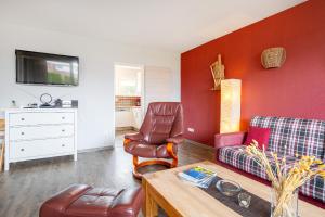 a living room with a couch and a chair at Bungalow Windsbraut in Norddeich