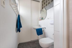 a white bathroom with a toilet and a sink at Bungalow Windsbraut in Norddeich +15 photos
