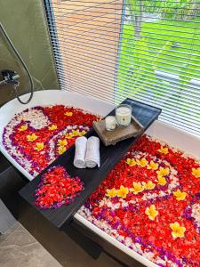 a bath tub covered in flowers in a room at Superior Luxury Loft with Working Desk, Instagramable Pool in Kerobokan