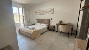 ein Schlafzimmer mit einem Bett, einem Tisch und einem Schreibtisch in der Unterkunft Yllen Rooms in Avola