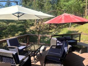 a deck with chairs and a table and an umbrella at Peaceful in Evergreen