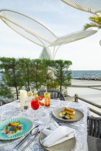 a table with plates of food on it with the ocean at Furaveri Maldives - COMPLIMENTARY ROUND-TRIP SEAPLANE TRANSFER FOR TWO FOR A MINIMUM OF 5 NIGHTS OR MORE FOR STAYS 1ST MAY 2026 TO 23RD DECEMBER 2026 in Raa Atoll +103 photos