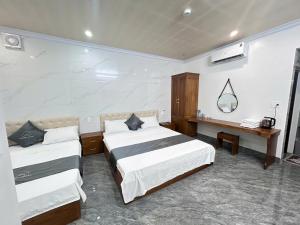 a hotel room with two beds and a mirror at Cloudy Hotel in Ha Giang