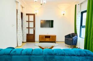 a living room with a blue couch and a table at Bj House in Douala