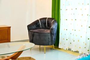 a leather chair sitting next to a glass table at Bj House in Douala