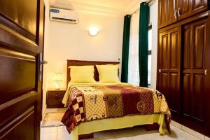 a bedroom with a bed and a window at Bj House in Douala