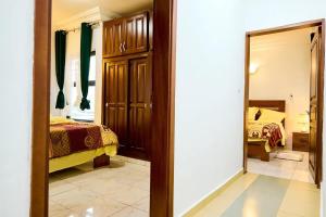 a view of a bedroom with a bed and a mirror at Bj House in Douala
