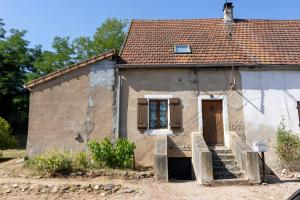 an old stone house with a staircase in front of it at Gîte de la Dheune in Essertenne