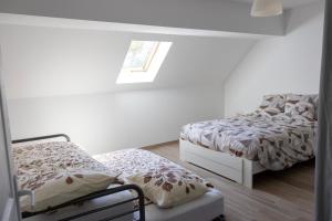 a bedroom with two beds and a window at Gîte de la Dheune in Essertenne