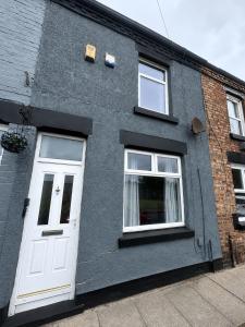 a gray building with a white door and windows at York House - Garston - 3 bedroom - Sleeps 6 in Liverpool