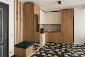 a kitchen with wooden cabinets and a checkered floor at Panoramic Sea Apartment in Kvariati