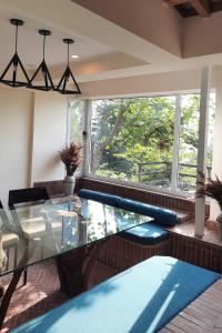 a living room with a glass table and a large window at Bhurban Valley Cottages 3 in Bhurban