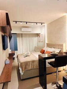 a bedroom with a bed and a desk in it at Desing Studio, luxo e Moderno Vila Velha-ES in Vila Velha