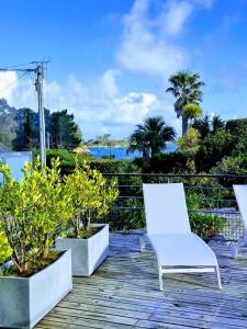 a white chair sitting on top of a wooden deck at Le bigorneau in Trégastel