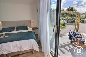 a bedroom with a bed and a sliding glass door at Le bigorneau in Trégastel